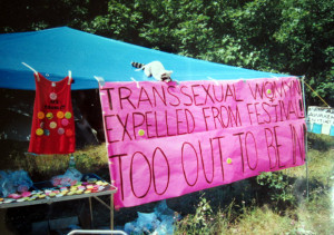 A protest sign reads, "Transsexual Women Expelled from Festival – Too Out to Be In"